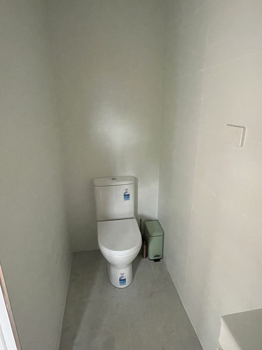 Ensuite toilet with floor-to-ceiling tiling on all walls